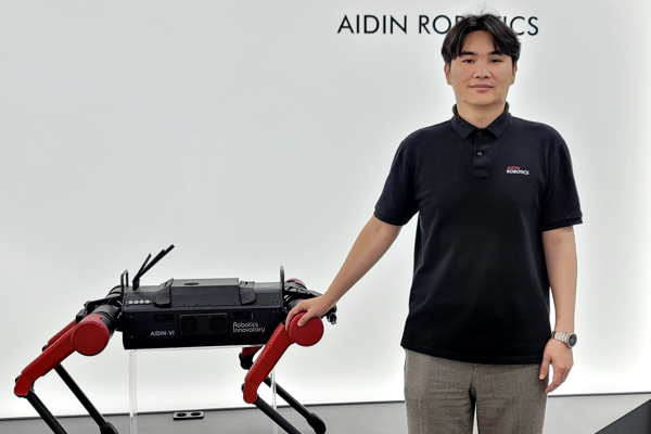 ▲에이딘로보틱스 이윤행 대표가 4족 보행 로봇을 배경으로 사진 촬영을 하고 있다. 