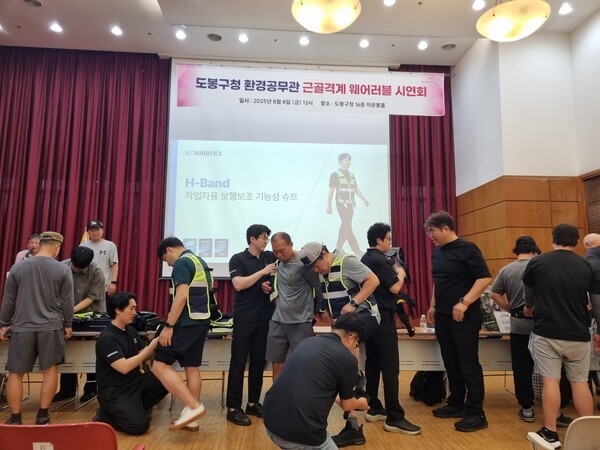 ▲도봉구 환경공무관들이 업체 관계자의 도움을 받아 ‘입는 바카라 카지노’을 착용해보고 있다(사진=도봉구)