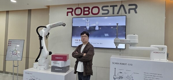 ▲배병주 로보스타 대표가 회사 내 전시된 수직다관절 바다 이야기 슬롯 머신과 스카라 바다 이야기 슬롯 머신 앞에서 포즈를 취했다.