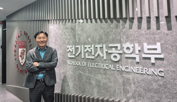 ▲임묘택 제어한게임 슬롯 머신시스템학회장이 고려대학교 전기전자공학부 교수로 재직 중인 학부 CI를 배경으로 환하게 웃고 있다.