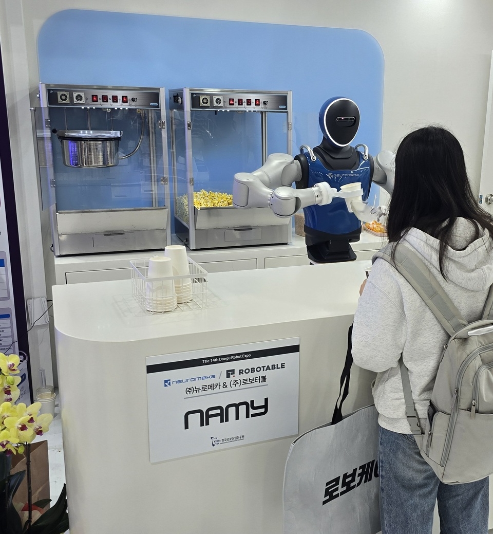 ▲로보터블이 대구 국제유투벳산업전·FIX 2025에 참가해, 뉴로메카 휴머노이드 ‘NAMY’를 활용한 팝콘 제공 서비스 시연으로 눈길을 모았다. (사진=로보터블)