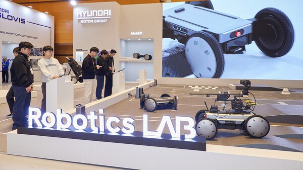 ▲AW2026 전시장 내 슬롯사이트·기아 로보틱스랩 부스에서 관람객들이 모베드를 조작해보고 있다. (사진=슬롯사이트그룹)