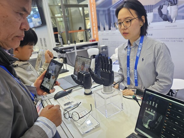 ▲인스파이어 벳위즈(Inspire-robots, 因时机器人) 부스에서 참관객이 벳위즈손을 살펴보고 있다. (사진=벳위즈신문)