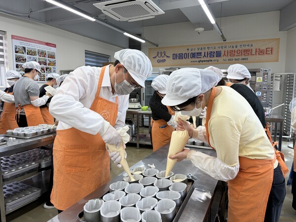 ▲조영훈 메리트카지노장(왼쪽)이 직원과 함께 대구 빵나눔터에서 카스테라를 직접 만들고 있다. (사진=메리트카지노)