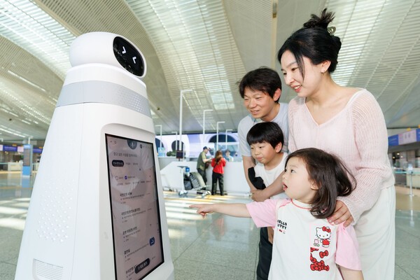 ▲인천공항을 찾은 여객들이 안내·순찰 더킹플러스 카지노의 도움을 받으며 공항 정보를 확인하고 있다. (사진=인천국제공항공사)